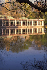 Fototapeta na wymiar park architecture on a lake lakeside boathouse and reflection in water in a city park 