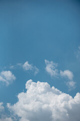 white clouds in the sky against a clear day.