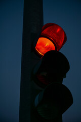Rote Ampel, Ampel leuchtet rot und signalisiert Stop oder Halt, dunkel bei Nacht