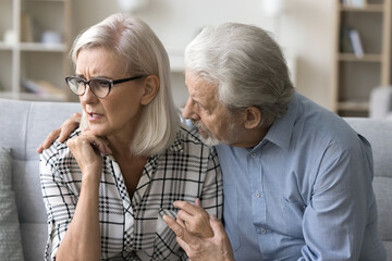 Worried old husband hugging anxious wife with mental disorder, panic attack, consoling depressed upset woman, touching shoulders, giving help, support. Couple getting problems, bad news