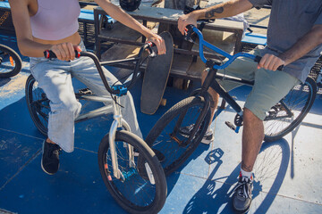 Young happy couple enjoy BMX riding at the skatepark