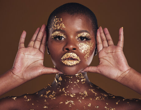 Cosmetics, portrait and black woman with gold makeup on brown background with glitter paint. Shine, glow and African model in studio for beauty, fashion art and aesthetic freedom in luxury skincare.