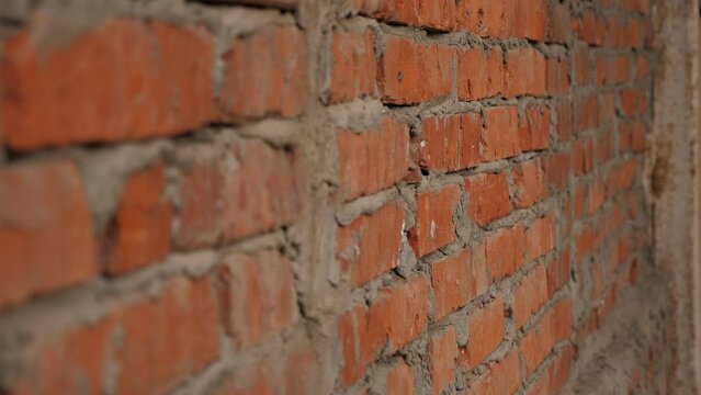 Close-up of an old brick wall in a ruined building. The windows at the abandoned factory were laid with red bricks. A red brick wall on a construction site.