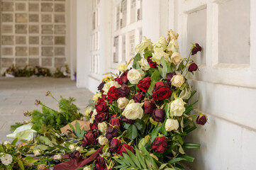 Abgelegte Rosen vor einer Urnenwand