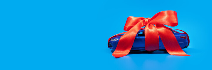 a gift car banner, wrapped prize on a blue background, buying and selling cars, copy space