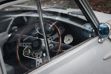 Closeup of old vintage retro car with classic wood wheel steering. Antique automotive vehicle and...