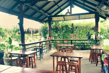 The wooden tables in front of the coffee shop and iron tables have soft cushions.