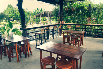 Fototapeta na wymiar The wooden tables in front of the coffee shop and iron tables have soft cushions.