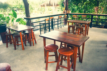 The wooden tables in front of the coffee shop and iron tables have soft cushions.