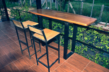 The wooden tables in front of the coffee shop and iron tables have soft cushions.