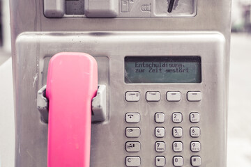 Auf dem Display eines öffentlichen Münztelefons steht 