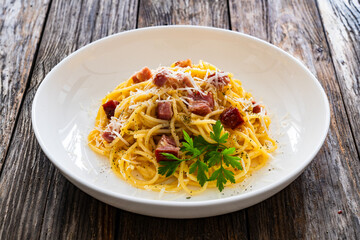Spaghetti carbonara on wooden table

