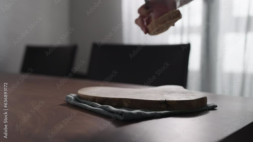 Wall mural Slow motion man slicing ciabatta on olive wood board