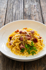 Spaghetti carbonara on wooden table
