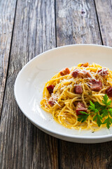 Spaghetti carbonara on wooden table

