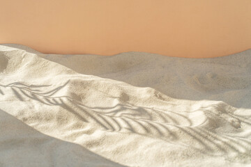 Abstract shadows of tropical leaves leave shadows on the texture of the sand. Abstract texture trendy beige background, nature concept.