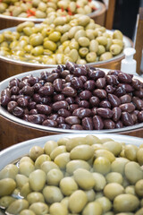 Fresh olives in barrels on street market or in grocery shop. Snack containing vitamins