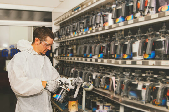 Professional painters mix car paint formulas in the paint storage room and grade quality paints by mixing formulas with a standard 2K paint mix ratio according to customer requirements. 