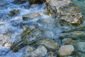 Close up of crystal clear water and stones on a mountain river