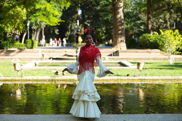 Young black woman dressed as a flamenco dancer stands in a famous park next to a duck pond in...