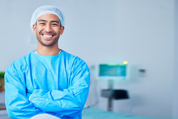 Portrait, surgeon and Asian man with arms crossed in hospital, healthcare and wellness. Face, happy doctor and medical professional, expert nurse and confident surgery employee in scrubs in Cambodia