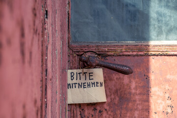 An einer alten Tür hängt ein Schild, auf dem steht 