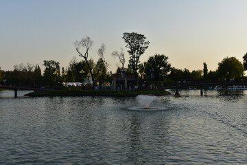 Obraz premium Sunset over the river, Park Buildings from Magic city