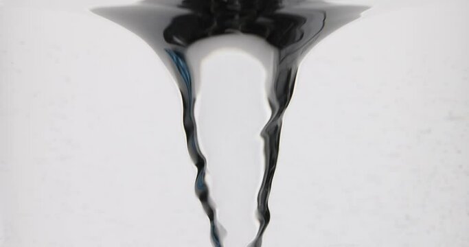 Transparent liquid swirls on white background. Natural swirling water flow. Clear water swirling rapidly in front of studio wall slow motion