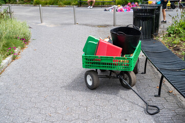 Green groundskeeper garden wagon with tools in urban park