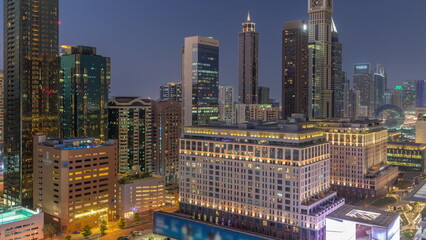 Fototapeta na wymiar Dubai International Financial district aerial day to night timelapse. Panoramic view of business and financial office towers.