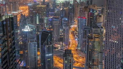 Skyline view of Dubai Marina showing canal surrounded by skyscrapers along shoreline all night timelapse. DUBAI, UAE