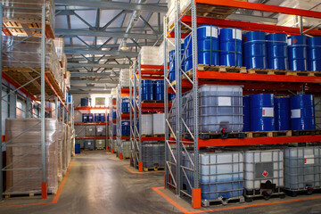 Warehouse chemical products. Storage interior with shelving. Metal and plastic barrels on pallets....