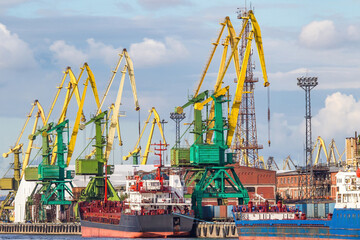 Sea port. Ship in cargo harbor. Gantry cranes in port. Container ship is waiting for loading of...