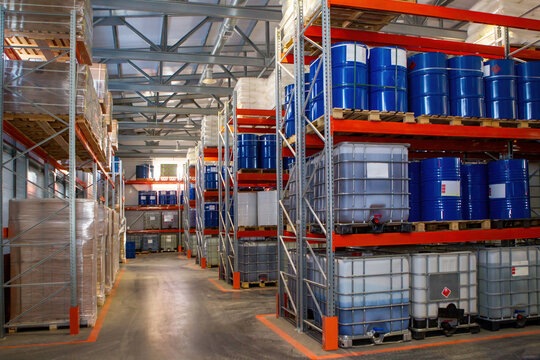 Warehouse chemical products. Storage interior with shelving. Metal and plastic barrels on pallets. Warehouse of manufacturing company. Oil refinery storage inside. Enterprise interior without people