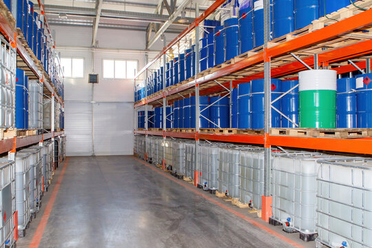 Factory warehouse. Factory storage. Manufactory storage area. Interior of chemical plant warehouse. Hangar with shelving for barrels. Multi-tier racks with cisterns. Industrial storage