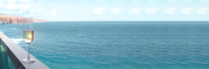 Obraz premium Luxury travel banner. Champagne glasses on balcony with ocean sunset view on Caribbean vacation.