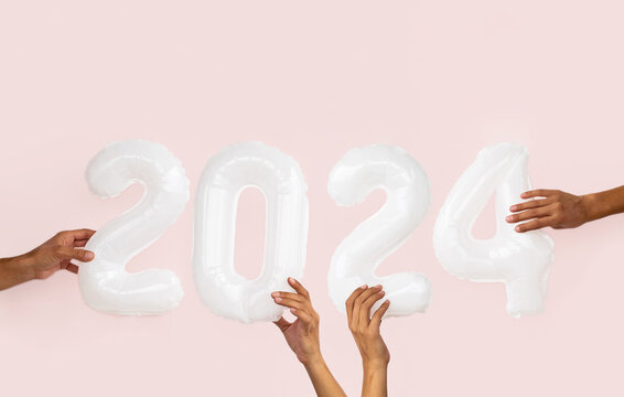 Female hands hold balloons 2024 number. New Year holidays fancy background.