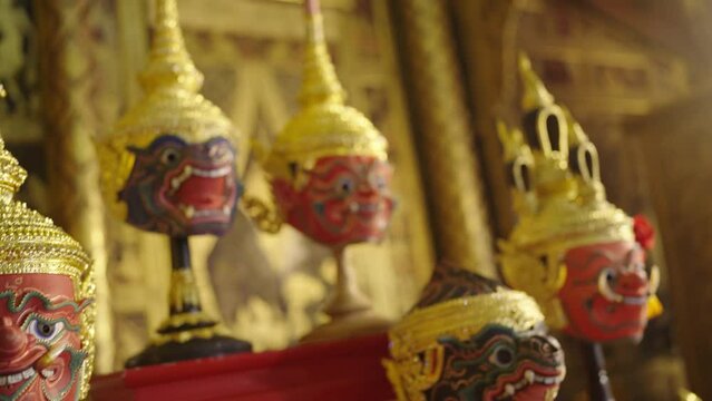 Close up of beautiful ancient traditional Thai pattern Pantomime or Khon masks are set up on wooden shelves with various styles of charactor.