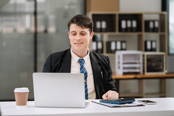 Businessman working with laptop and using a calculator to calculate the numbers of static in...