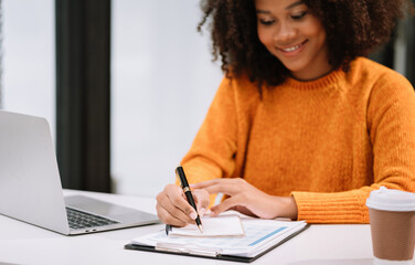 Female writes information businessman working on laptop computer writing business plan while sitting in office.