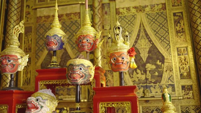 Side view of beautiful ancient traditional Thai pattern Pantomime or Khon masks are set up on wooden shelves with various styles of charactor.