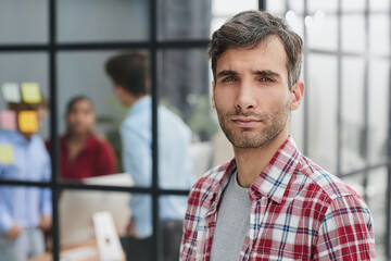 Handsome brunette guy pose alone at workplace or loft apartment look at camera