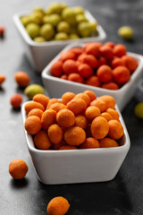 Assortment of crunchy peanuts snack. Green wasabi, Red spicy chilli, yellow jalapeno cheese