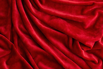 Background from red velvet fabric. The red fabric is folded in layers. Velvet fabric looks rich.