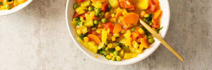 Minestrone soup from zucchini and tomato, onion and carrot, corn and peas with parsley, top view of soup plates, vegetarian soup banner