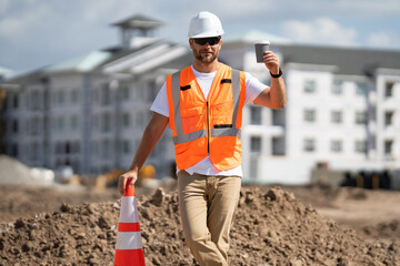 Construction site worker in helmet working outdoor. A builder in a safety hard hat at constructing...