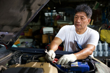 Fototapeta na wymiar mechanic worker checking and fixing a car in garage
