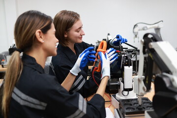 Fototapeta na wymiar Caucasian two young female engineers learning robotic arm in training class together, innovation and development smart 4.0 factory concept.