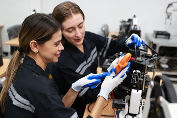 Caucasian two young female engineers learning robotic arm in training class together, innovation and development smart 4.0 factory concept.