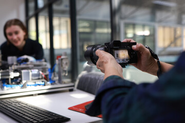 engineer using a camera to take photos of  a motherboard prototype  robot in the training class